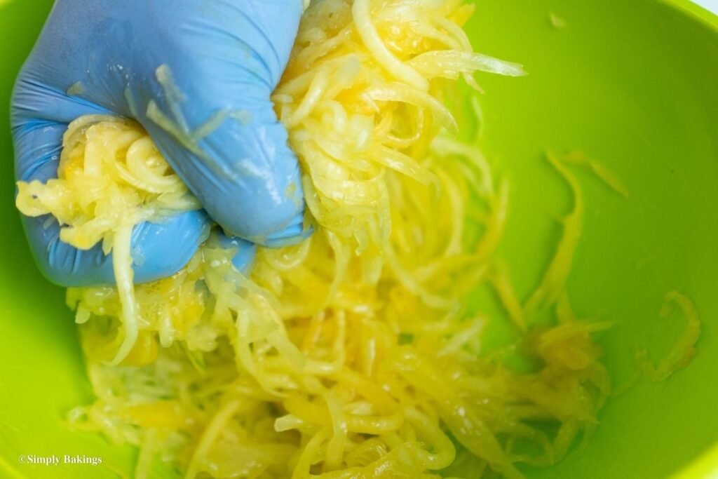 squeezing the juice out of the grated papaya