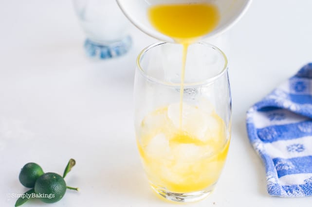 adding pure and freshly squeezed calamansi juice to the glass with ice cubes