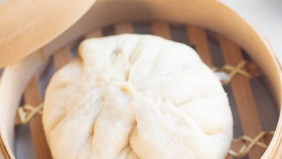 steamed vegan siopao in a bamboo steamer