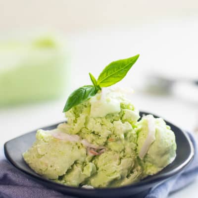 buko pandan ice cream with coconut strips on a black plate