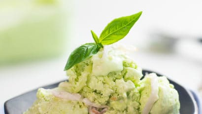 buko pandan ice cream with coconut strips on a black plate
