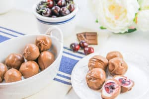 chocolate covered cherries in a white plate, bowl, and cup