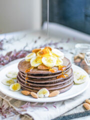 agave syrup being poured on vegan chocolate pancakes
