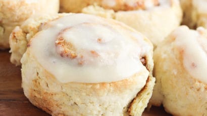 pumpkin cinnamon rolls on a brown cutting board