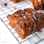 a slice of Pumpkin Keto Brownies drizzled with melted chocolate on a cooling wire rack