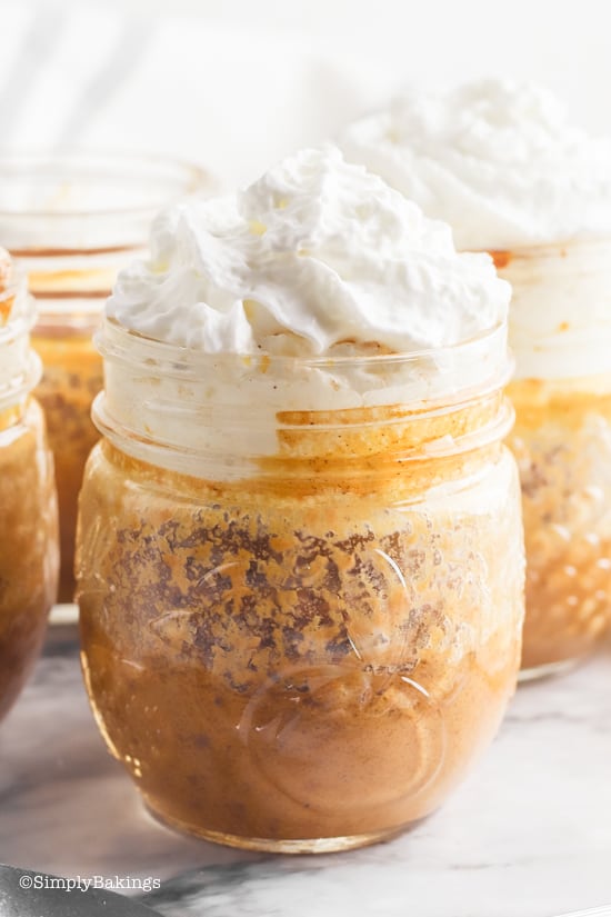pumpkin pie in mason jars topped with whipped cream