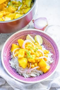 Potato and Chickpea Curry over white rice in a pink bowl