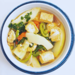 hot vegan tinola soup in a bowl on a white table