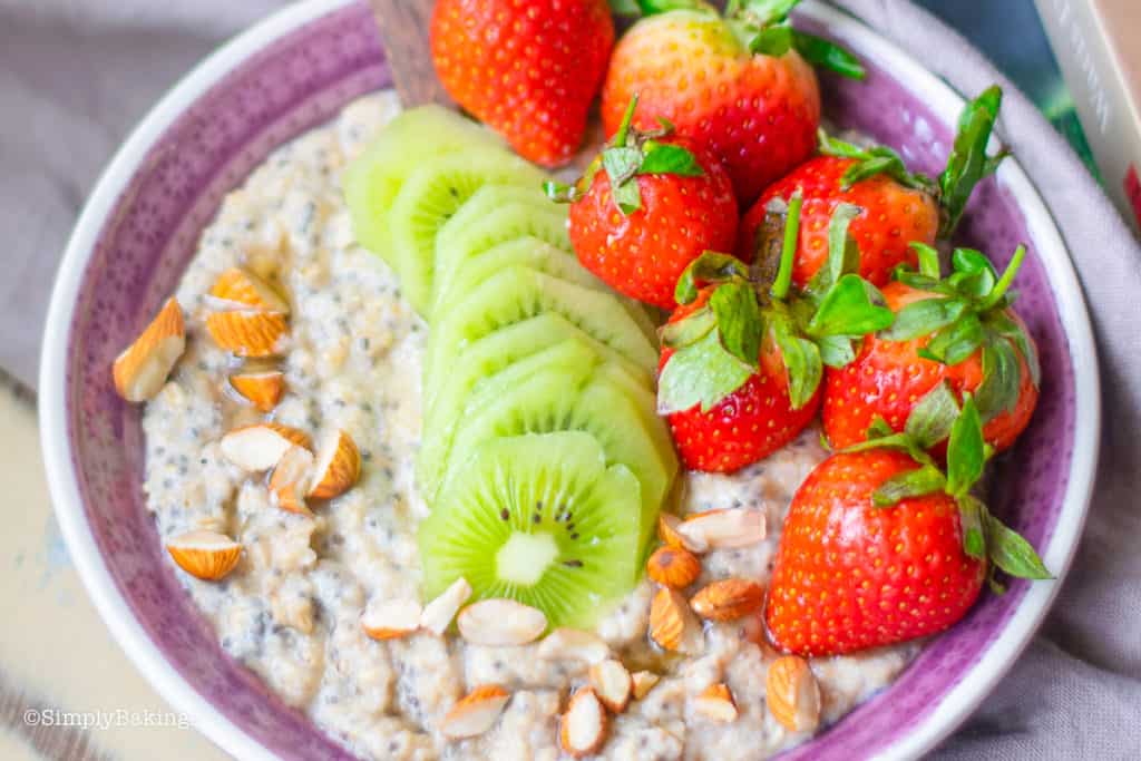 Chai Oatmeal topped with kiwi, strawberry and almonds on a purple bowl