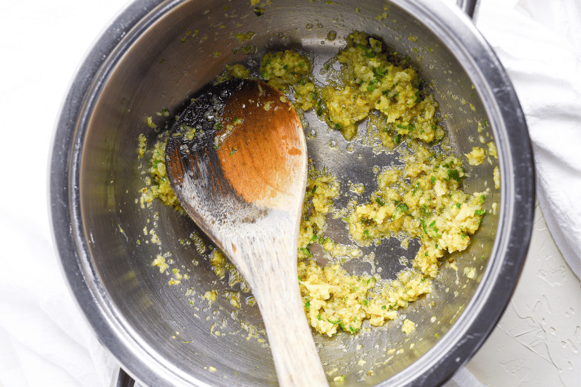 spices cooked in a soup pot with a wooden ladle