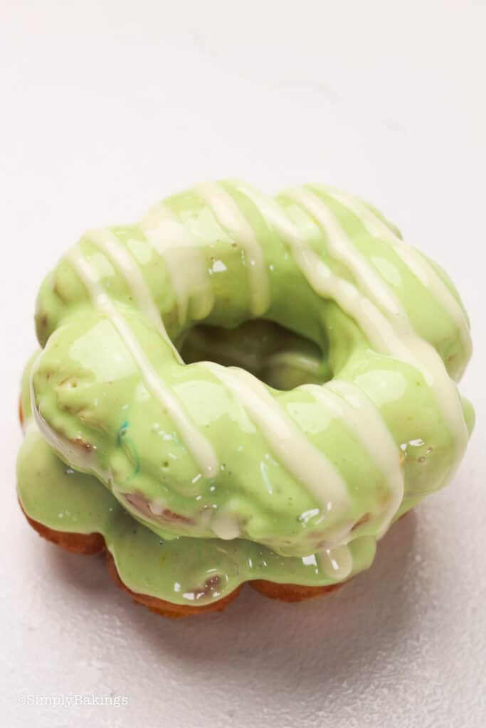two matcha mochi donuts on a white surface