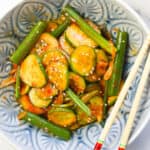 Asian cucumber salad in a bowl with a pair of chopsticks