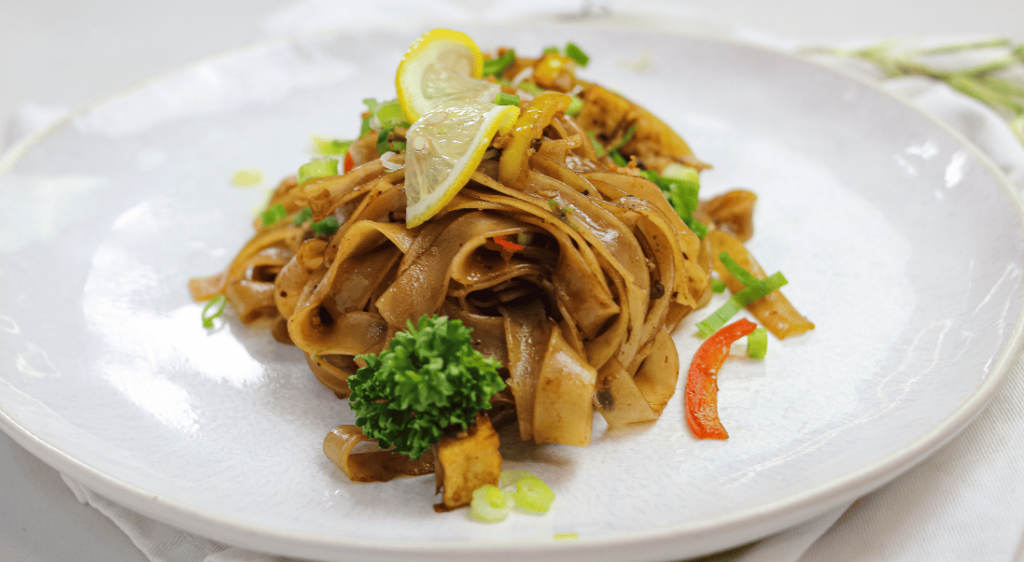 savory malaysian noodles on white plate