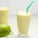 delicious green mango shake in a tall glass with a green straw