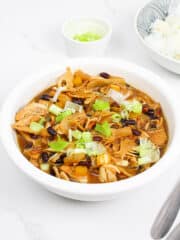 a bowl of jackfruit humba with a small bowl of spring onions and a bowl of steamed white rice