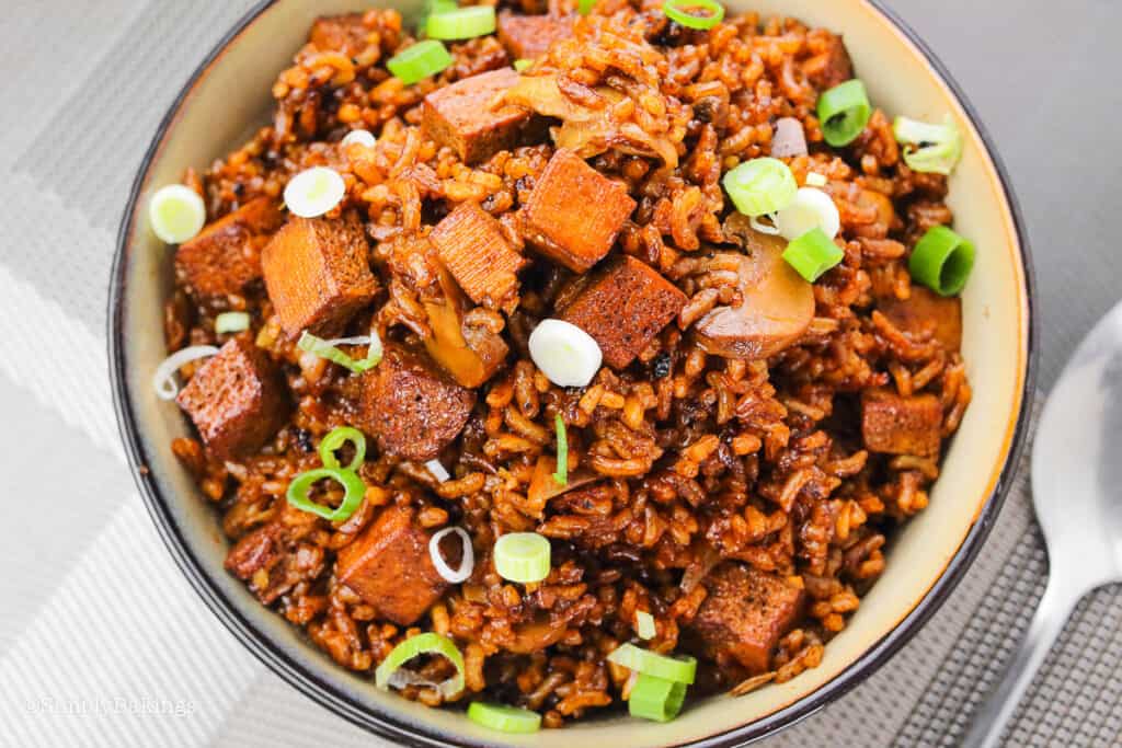 a bowl of tofu adobo rice topped with chopped green onions