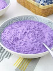 a bowl of Filipino ube champorado with a stainless spoon