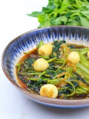 savory vegetarian kangkong with quail eggs in a blue bowl