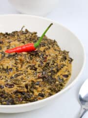 vegan laing garnished with a red chili in a white bowl