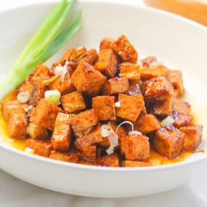 tofu salpicao served in a white bowl garnished with a green onion
