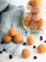 vegan blueberry truffles coated with cocoa powder in a glass container