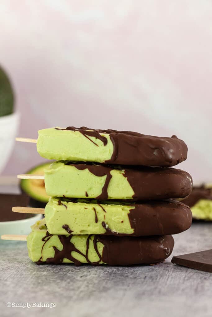 a stack of chocolate dipped avocado popsicles