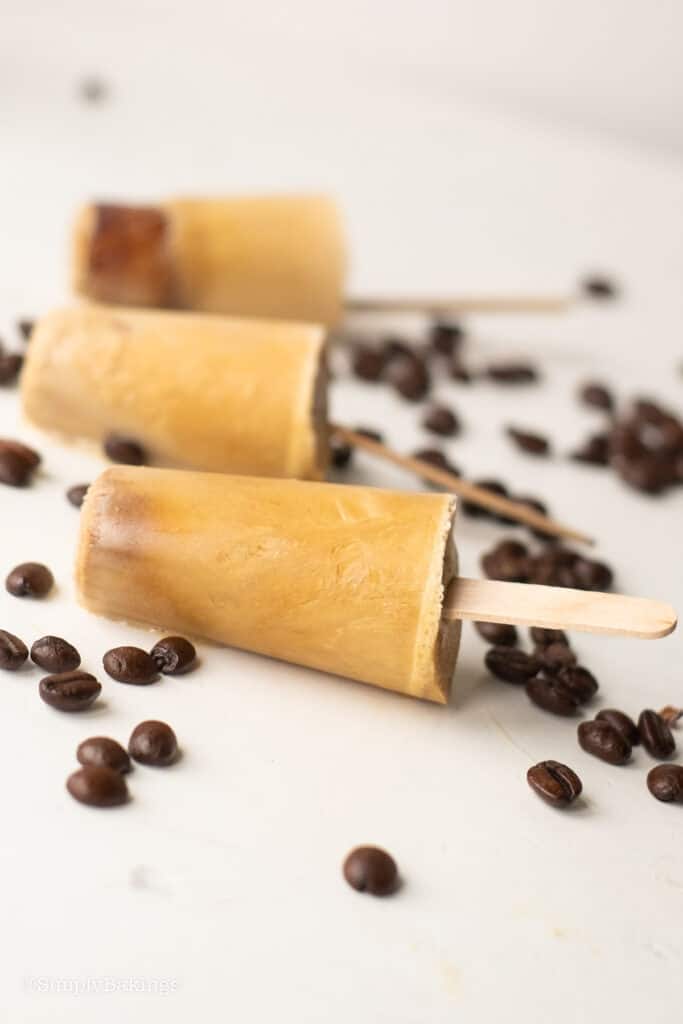 three Vietnamese Coffee Popsicles garnished with coffee beans
