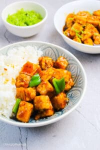 healthy and delicious crispy orange tofu served in a bowl with steamed rice