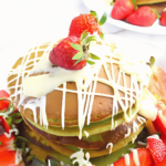yummy and fluffy match pancake with white sauce and strawberry on top