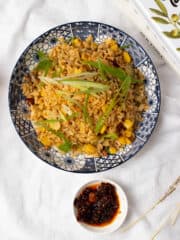 deliciously spicy chili oil fried rice served in a plate with a chili oil dip in a small white bowl