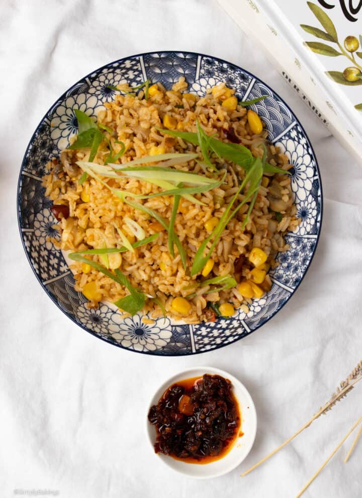 deliciously spicy chili oil fried rice served in a plate with a chili oil dip in a small white bowl