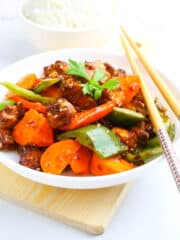 delicious Vegan Kung Pao Tofu served in a white bowl with chopsticks