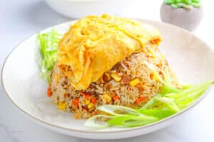 healthy and delicious Filipino-Style Omurice served on a white plate with green onion slices