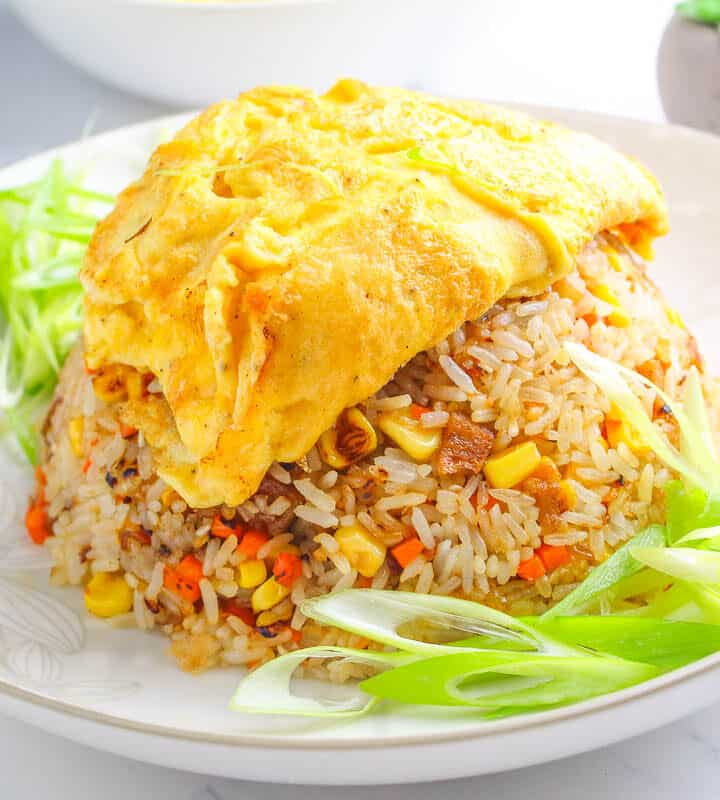 healthy and delicious Filipino-Style Omurice served on a white plate with green onion slices