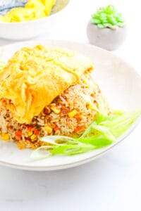 a serving of Filipino-Style Omurice on a white plate with green onion slices