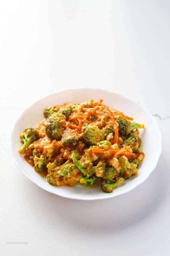 spicy broccoli and tofu with almond sauce in a white bowl 