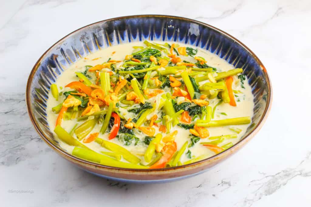 spicy and creamy water spinach in a china bowl on a white table