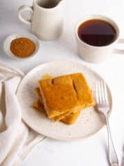 Sheet pan pumpkin pancakes next to a cup of coffee.