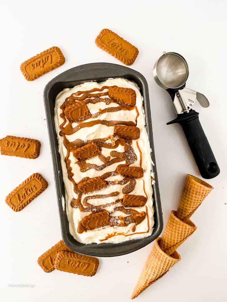 tasty cheesecake icecream spread on a loaf pan with cones and lotus biscoff biscuits on the side