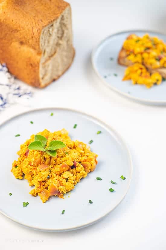 Tofu Scramble on white plate garnished with chopped chives