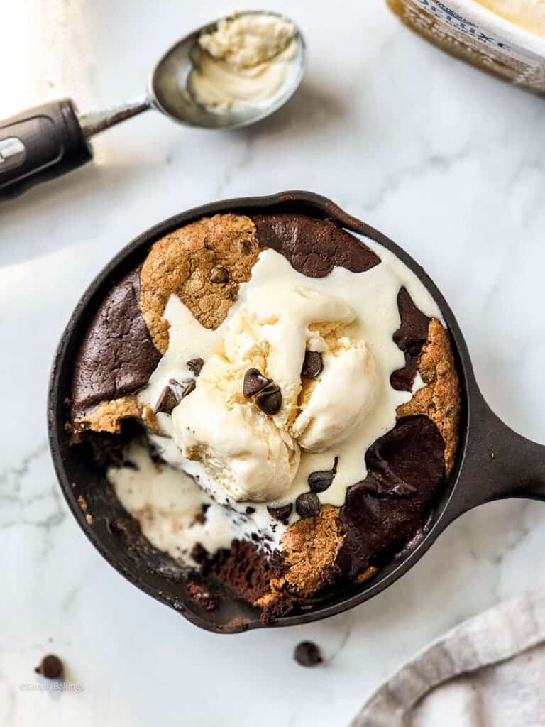 sweet and delicious skillet brookie topped with vanilla ice cream and chocolate chips