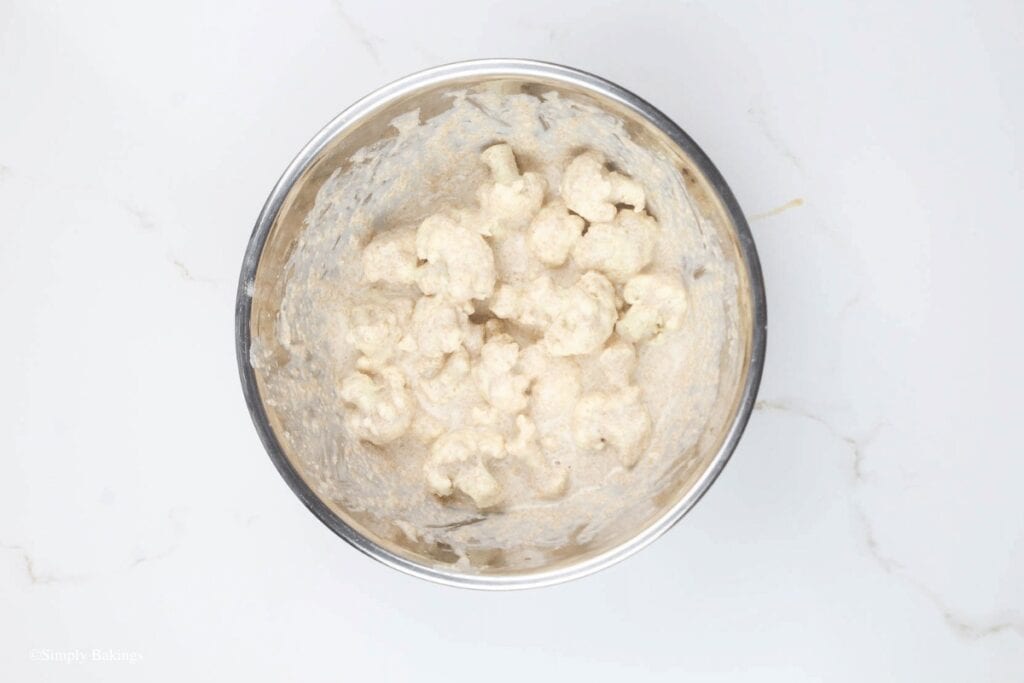 coated cauliflower florets on batter, image created by SimplyBakings