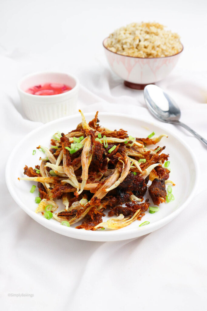 fried vegan dilis with spicy vinegar dip on a white plate