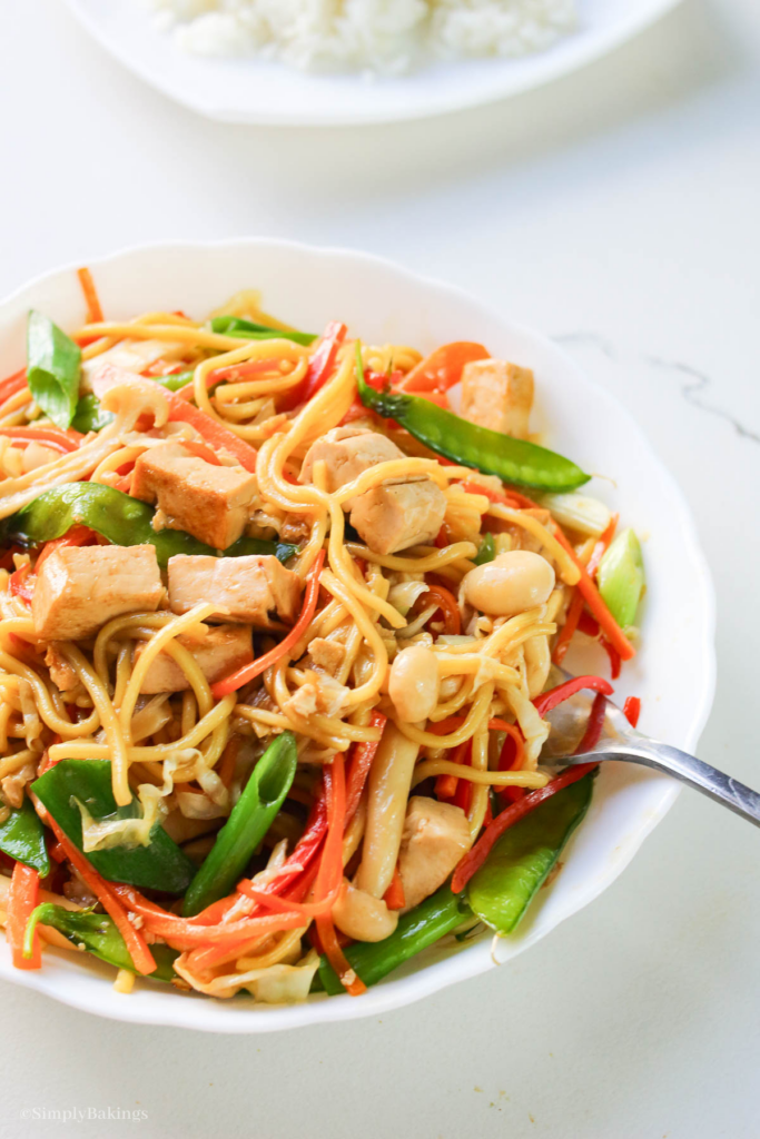 delicious Hunan Chow Mein in a white bowl with a stainless steel fork