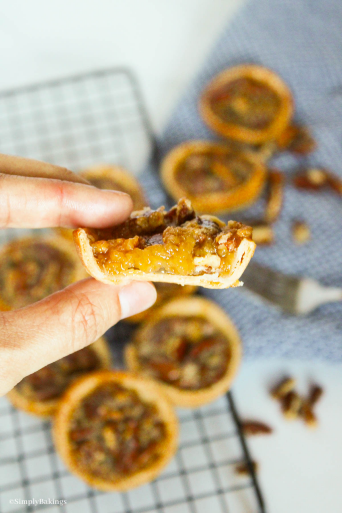 a half of mini pecan pie held by a hand