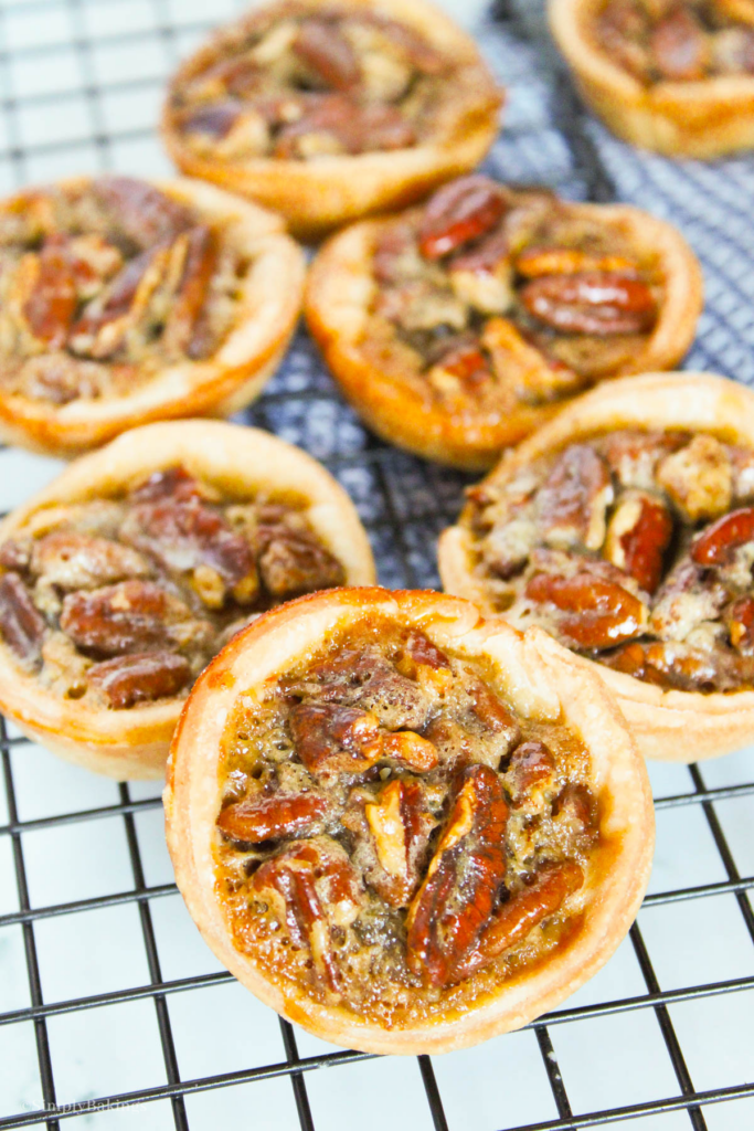 freshly baked mini pecan pies on a cooling rack