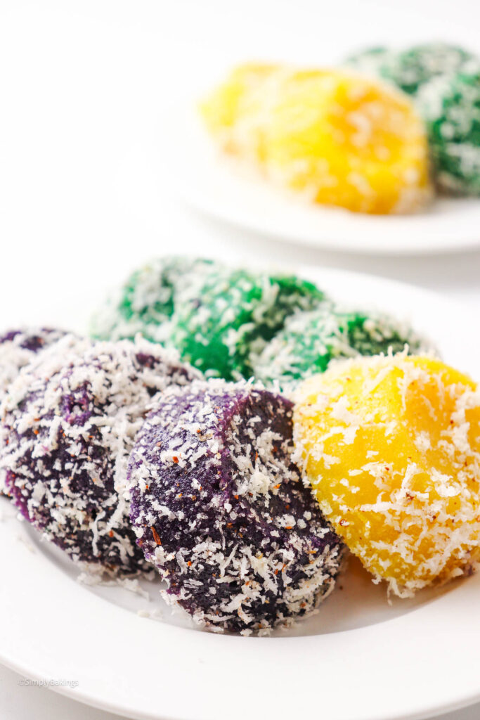White plate with grated cassava rolls coated in grated coconut