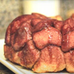 Monkey Bread on a white plate drizzled with caramel