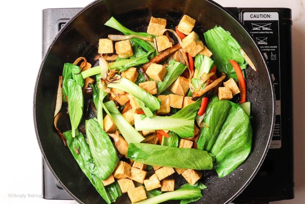Cut bok choy added into the pan with veggies