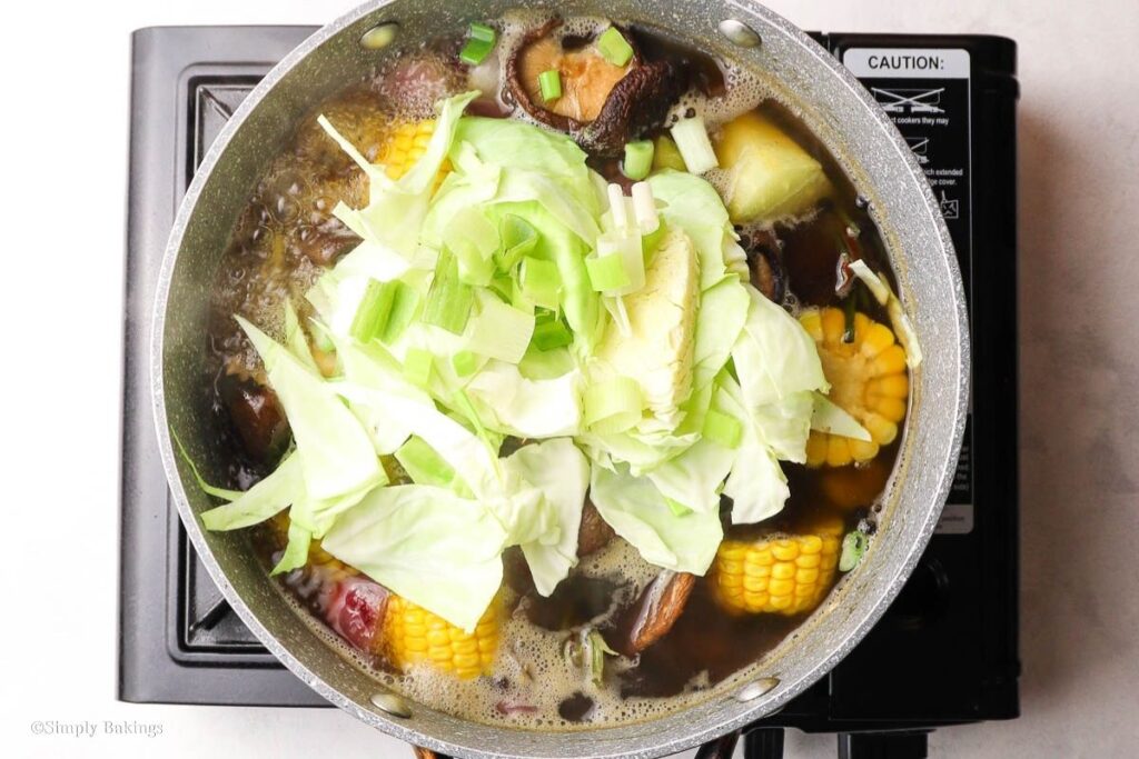 Cut cabbage and onions added to the soup mixture